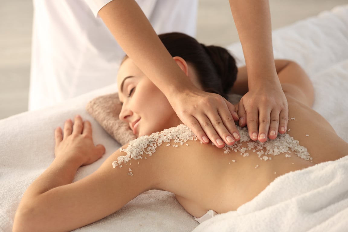 Person Putting Body Scrub on the Woman's Back